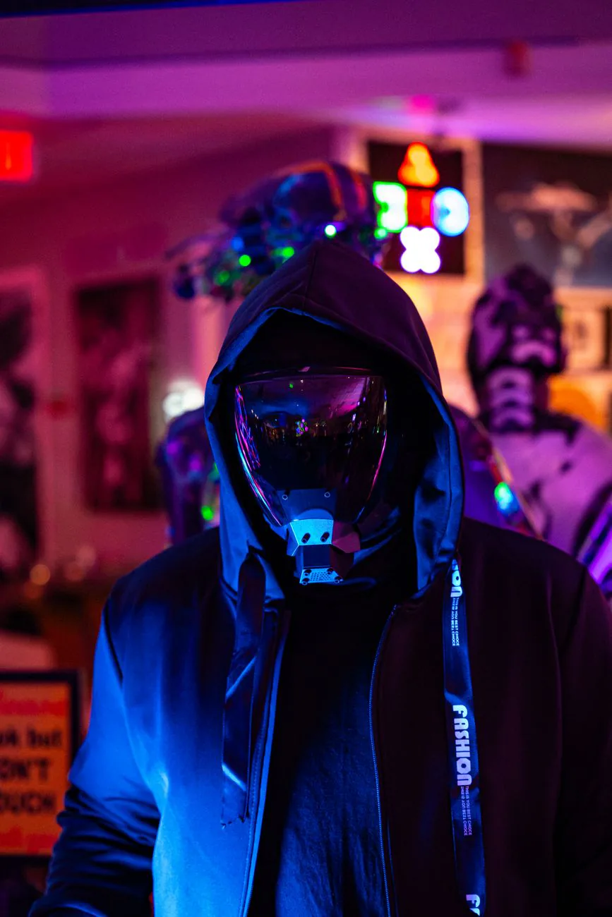 Person in reflective mask under vibrant neon